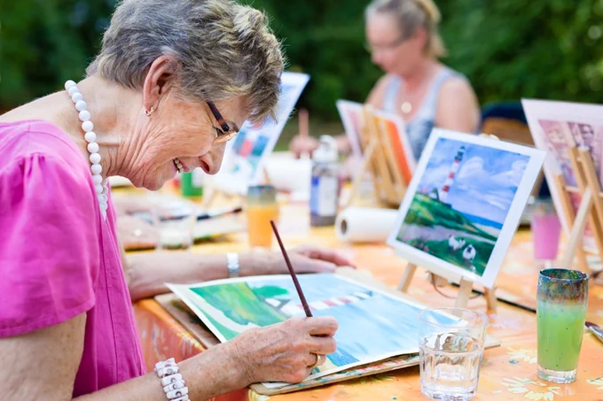 Older white woman taking part in an art class