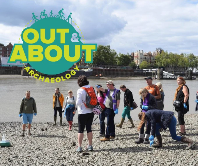 A group of adults and young people walking along a river bank in an urban area. A blue and green text logo reads "Out & About Archaeology"
