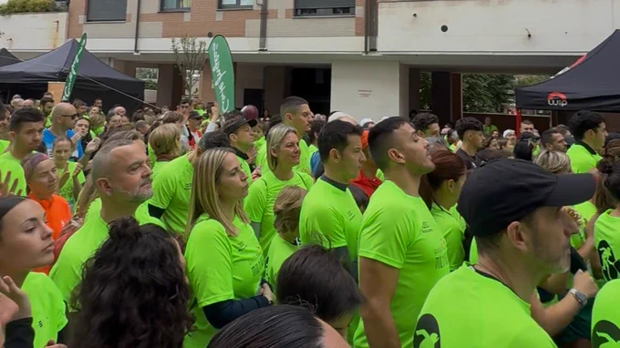 Imagen general de las personas participantes antes de la salida de la VII Carrera Solidaria por la Diversidad Funcional en Oviedo. La mayoría lleva camiseta oficial de la carrera de color verde fosforito y logos de la Fundación Mia o que hago e Integra CEE. 