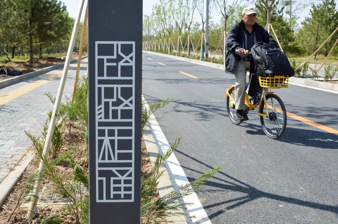 A cycling highway through a new residential district of Tongzhou on the outskirts of Beijing is lined with trees, plants, and lighting fixtures.