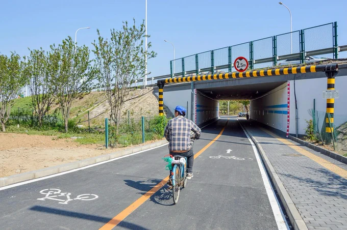 A cycling highway through a new residential district of Tongzhou on the outskirts of Beijing is lined with trees, plants, and lighting fixtures.
