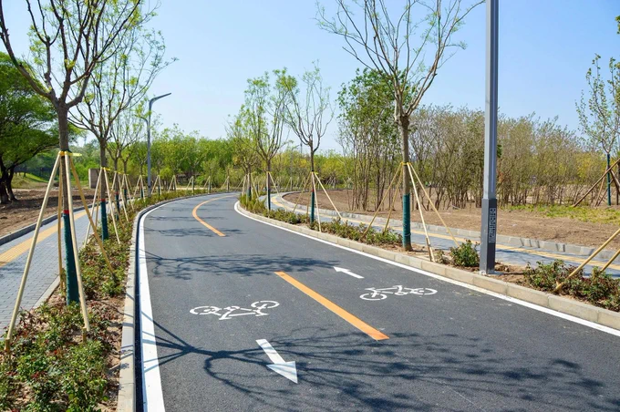 A cycling highway through a new residential district of Tongzhou on the outskirts of Beijing is lined with trees, plants, and lighting fixtures.
