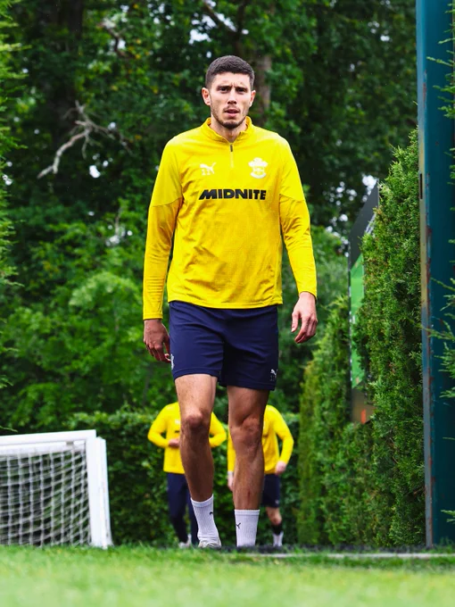 Ross Stewart walking out to training wearing a yellow training top at Staplewood Campus.