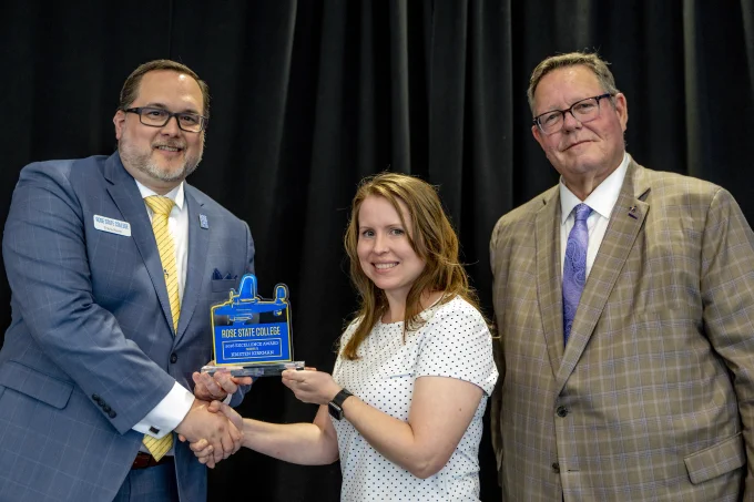 Professor Kristen Kirkman from Liberal Arts & Sciences receives an Excellence Award from RSC President Travis Hurst and RSC Board of Regents Chair Bill Croak.