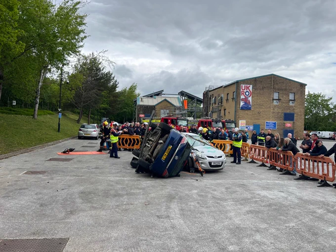 A road traffic collision mocked out with people watching next to a UKRO flag