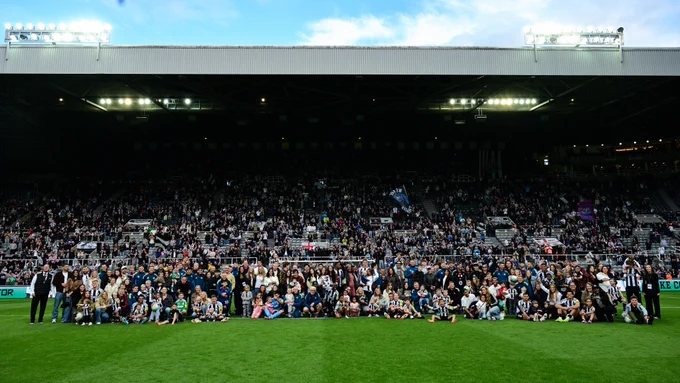 Players, staff and their families pose for a photo at full-time in front of the Gallowgate End. 