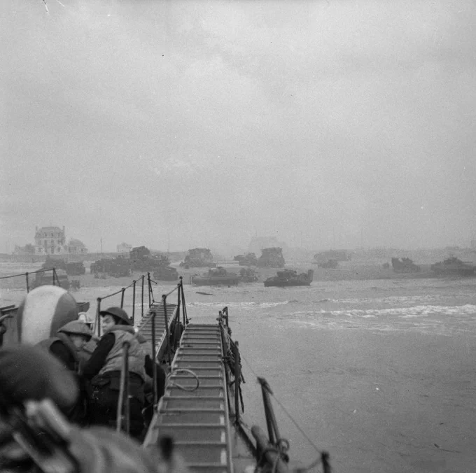 Commandos of 1st Special Service Brigade approach Queen Red beach in Normandy, Sword area, c. 0840 hours, 6 June 1944. Sherman DD tanks of 13th/18th Royal Hussars and the specialised armour of 79th Armoured Division can be seen crowding together on the beach ahead.