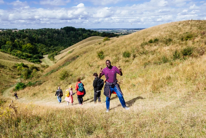 Photo taken by Aleksandra Warchol of the Barton Hills. Six people walking with one man smiling at the camera. 