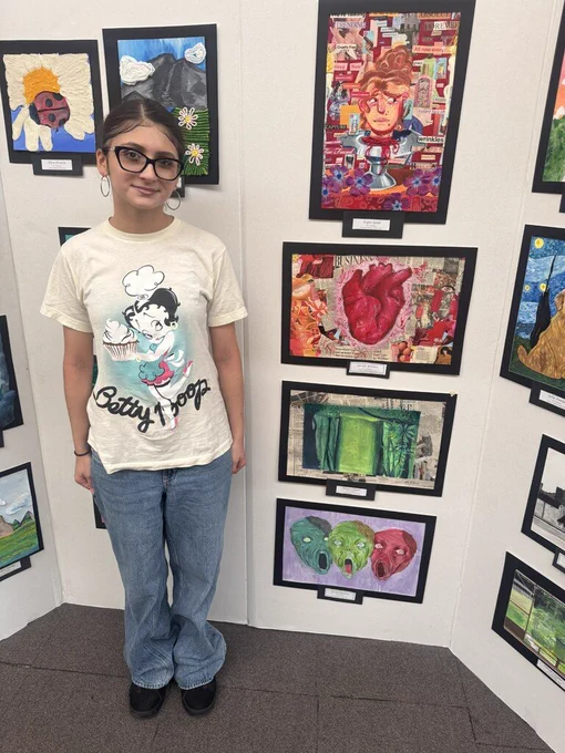 Student stands with artwork
