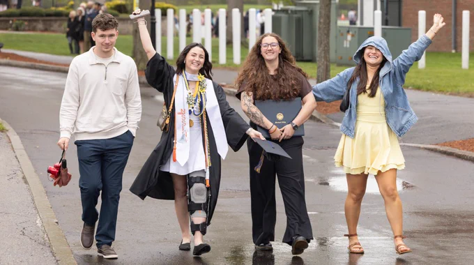 Four people walk and celebrate a Commencement, 