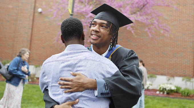 Two people hug at Commencement. 