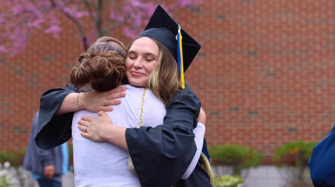 Two people hug at Commencement. 