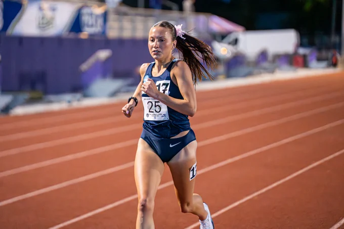 Madelyn Miller-Ross running outdoor track in blue UIS uniform