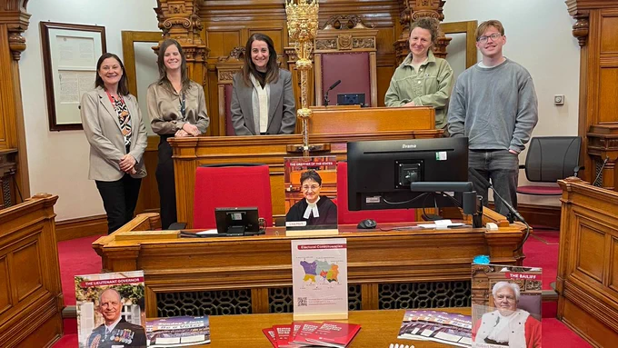 A group from Compass Jersey, who are studying Employment Law, gathered around the Bailiff's Chair in the States Chamber. 