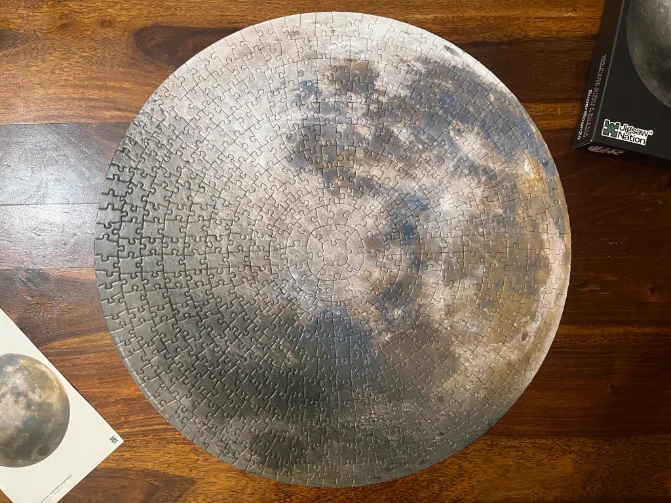 A complete 500 piece circular jigsaw puzzle of the moon