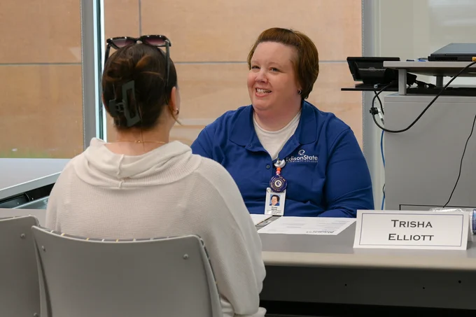 Two women seated at a table during a mock interview for the Business Communication class.