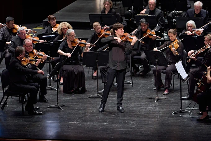 Violinst Joshua Bell playing his Stradivarius violin surrounded by New Jersey Symphony musicians.