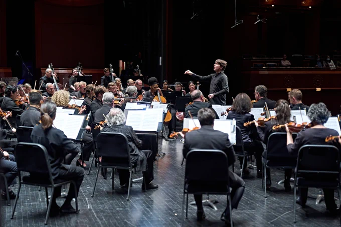 Joshua Bell leading a full orchestra of New Jersey Symphony musicians.