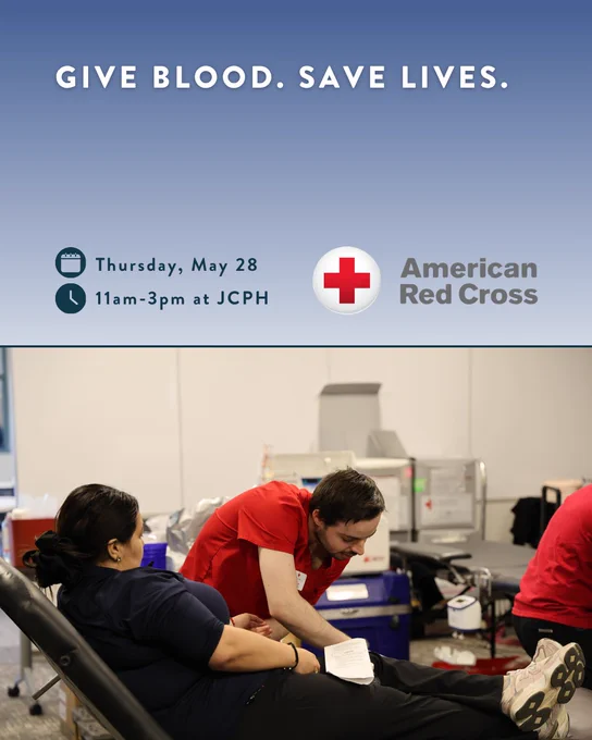 A person donates blood at an American Red Cross event, with a staff member assisting. The poster includes the text, "Give blood. Save lives." Event details: Thursday, May 28, 11am-3pm at JCPH.