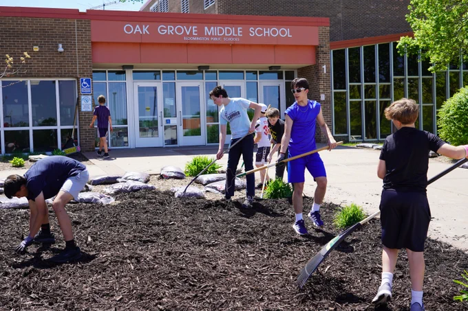 middle school students laying new mulch in the garden outside Oak Grove Middle School