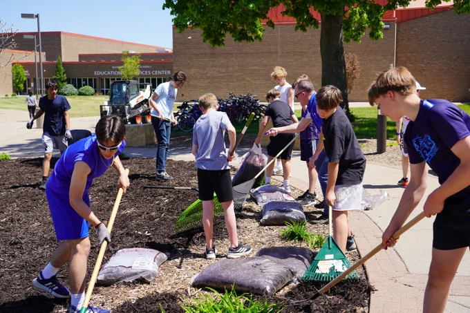 middle school students laying new mulch in the garden outside Oak Grove Middle School