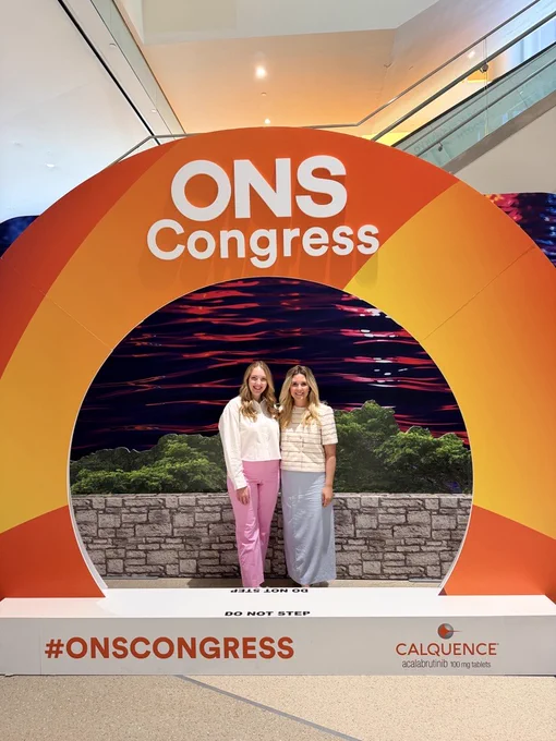 Kaylee Cooper and Lindsay Chorney standing under a ONS Congress display.