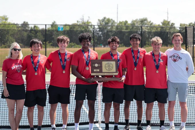 Blue Valley West Boys Tennis posing with the 6A state championship trophy on a tennis court.