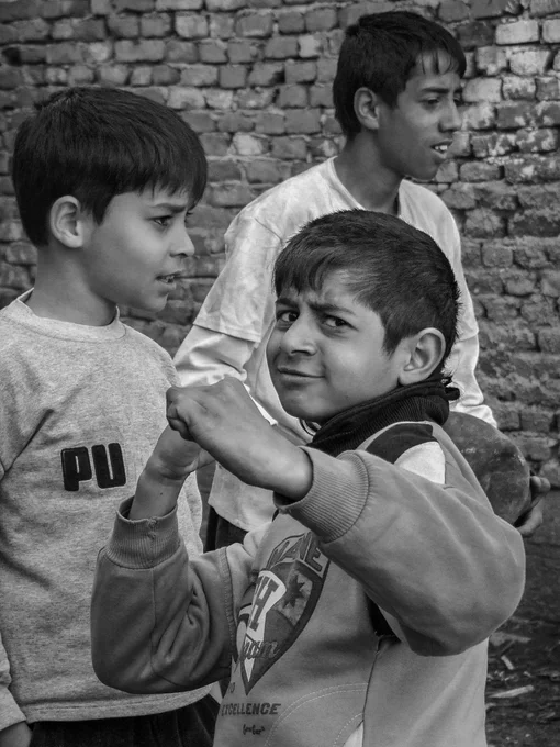 Black-and-white documentary photograph of Roma boys in the Gračanica enclave in Central Kosovo in 2008, standing together outdoors and looking into the camera. The image captures everyday life in a tense post-conflict environment. Photograph by Serbian photographer from Kosovo and Metohija, Ivan Maksimović.