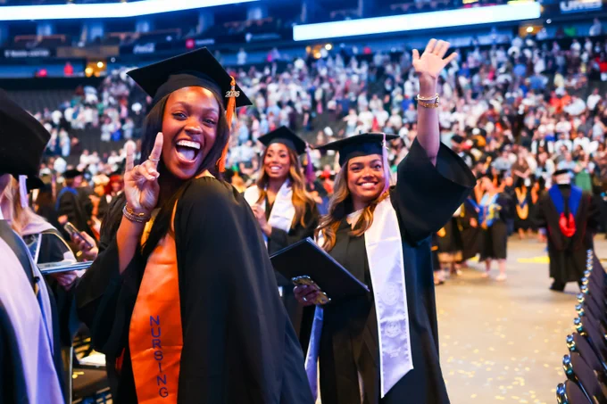 Students pose and cheer as they walk out after the Commencement ceremony.