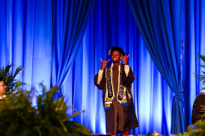 A student poses as he walks out on the Commencement stage.