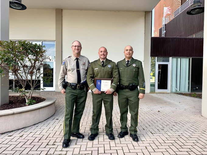 Transit Patrol Division Lieutenant Jeff Taylor and Captain Jose Cardoza pose for a picture with Deputy Navarro and his award.
