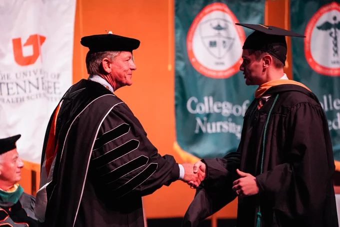 President Boyd shaking graduates hand