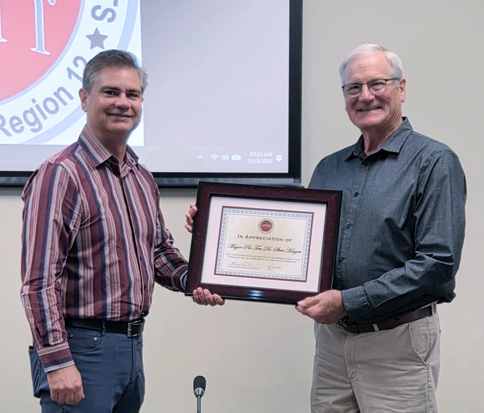 Pflugerville Mayor Doug Weiss presents former Granite Shoals Mayor Pro Tem Dr. Steve Hougen with a certificate for his services on the CAPCOG Executive Committee.
