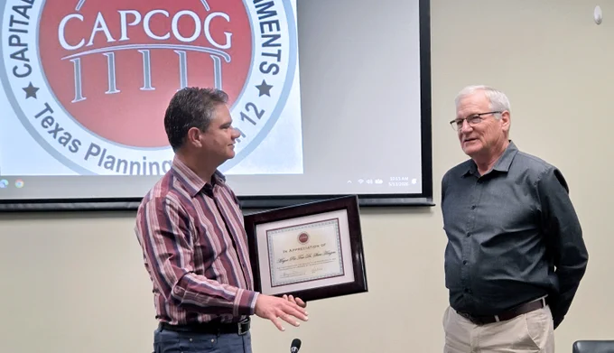 Pflugerville Mayor Doug Weiss presents former Granite Shoals Mayor Pro Tem Dr. Steve Hougen with a certificate for his services on the CAPCOG Executive Committee.