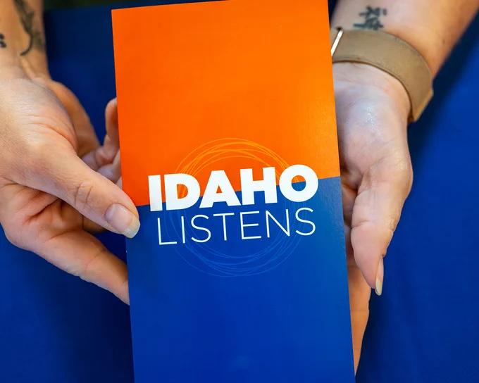 Boise State Idaho Listens brochure being held in someone's hands. 
