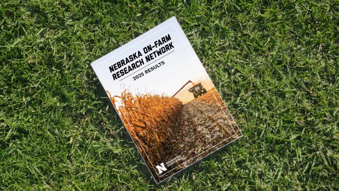 Booklet featuring a cornfield and combine harvester resting on green grass.