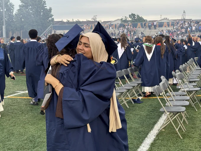 Two Chargers hug after the graduation ceremony.