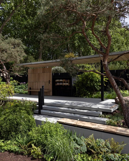 picture of a garden with a platform and trees around it