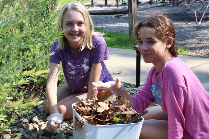 Students pick up old branches, leaves and weeds at Grand Vue's mini golf course.