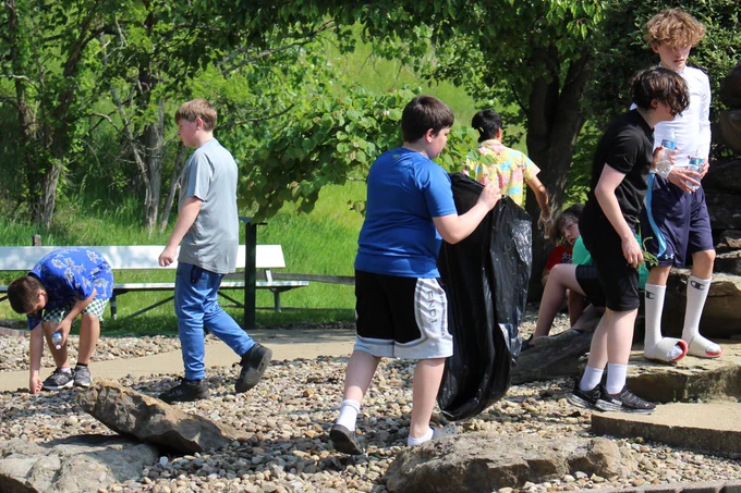 Students pick up old branches, leaves and weeds at Grand Vue's mini golf course.