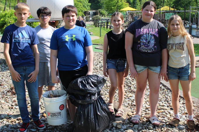 Students pick up old branches, leaves and weeds at Grand Vue's mini golf course.