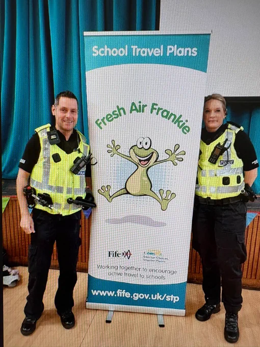 Two police officers in high viz next to a Fife Council sign promoting road safety