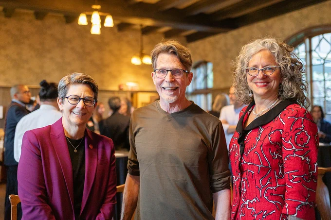 Lisa A. Freeman, Rick Bayless, and Kim Potowski stand together in the Jane Addams Hull House during a celebration