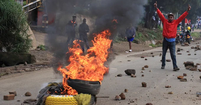 "A man demonstrates near a fire during a public transport strike over fuel prices in Nairobi, Kenya, Monday, May 18, 2026. (AP Photo/Andrew Kasuku)".