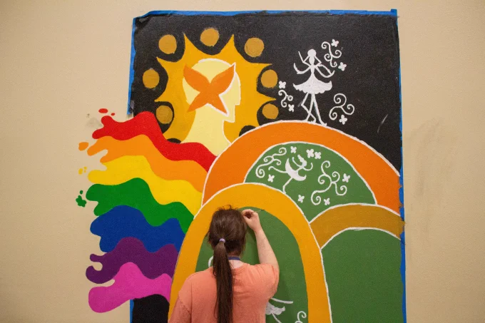 Photo of Zane Silsby working on the mural.
