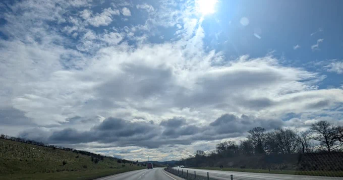 A sunny blue sky above a road.