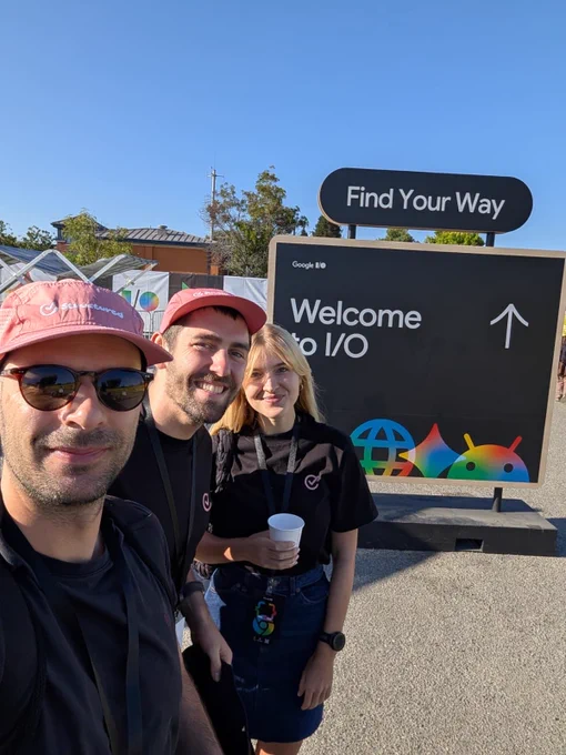 Rui, Isabella and Leo standing in front of a “Welcome to I/O” sign.