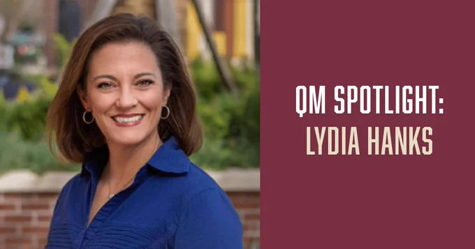 To the left is a picture of a woman with brown hair wearing a blue shirt. To the right is a garnet background with an overlay of text, "QM Spotlight: Lydia Hanks."