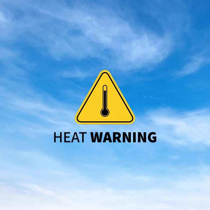 A yellow triangular warning sign with a thermometer symbol, accompanied by the text "Heat Warning," is set against a clear blue sky background.