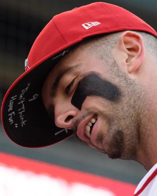 A close up, low angle photo of Zach Neto taken before the start of the Angels-Athletics game on May 18. The under bill of Neto's red Angels hat has a handwritten message reading, "Don't Think Have Fun."
